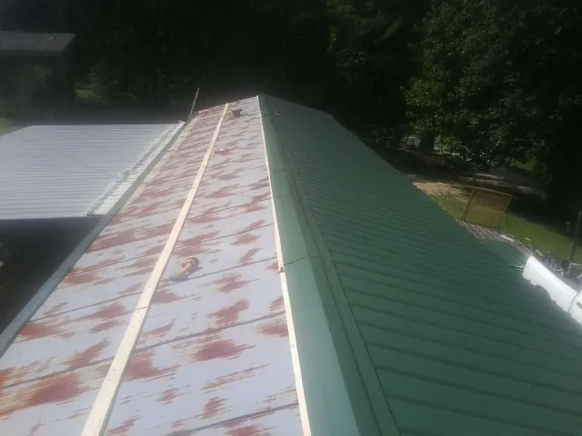 Old rusted panels beside newly installed green metal roofing — Wind Damage Roof Repair by Roofing Brothers in Burnt Ranch