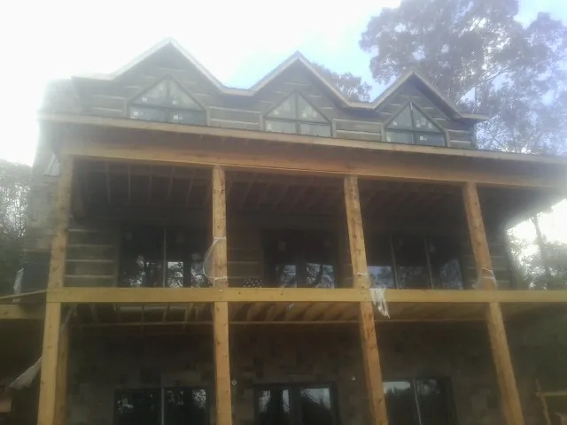 Dormers and porch framing on a large log home under construction — Roof Coating work by our crew in Burnt Ranch