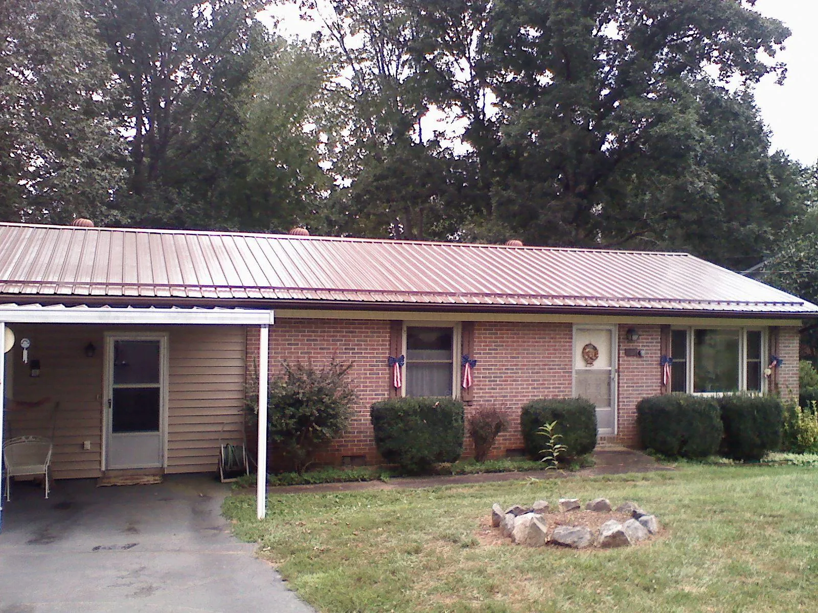 Bronze metal roof and carport on a brick ranch home — Roof Repair work by our crew in Burnt Ranch